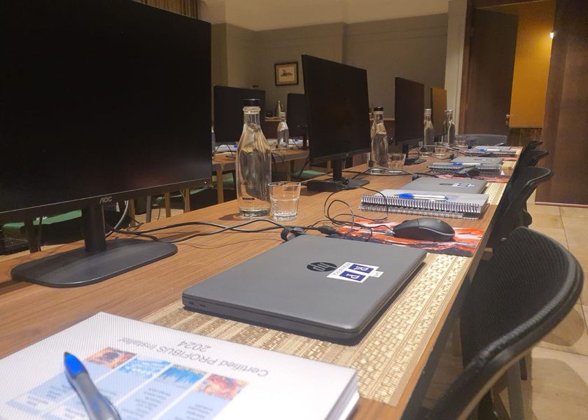 Puesto de trabajo con notebook, monitor y manual del curso